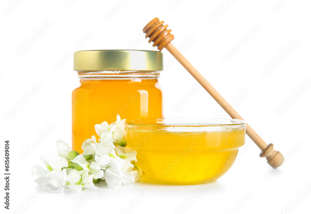 Jar and bowl of honey with flowers of acacia on white background