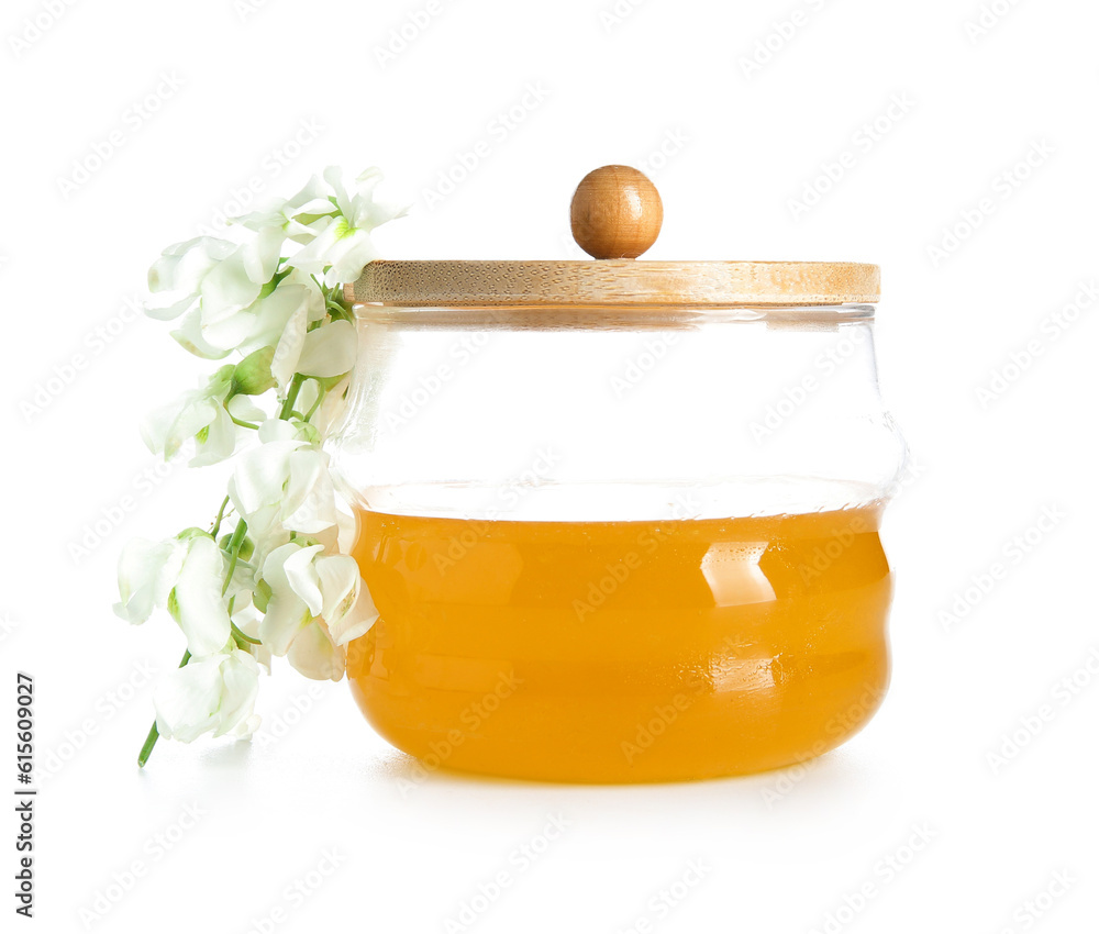 Jar of honey with flowers of acacia on white background