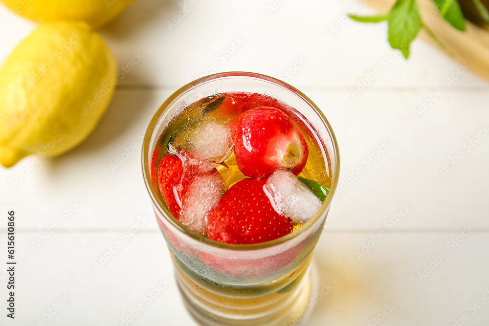 Glass of ice tea with strawberry and mint on white background