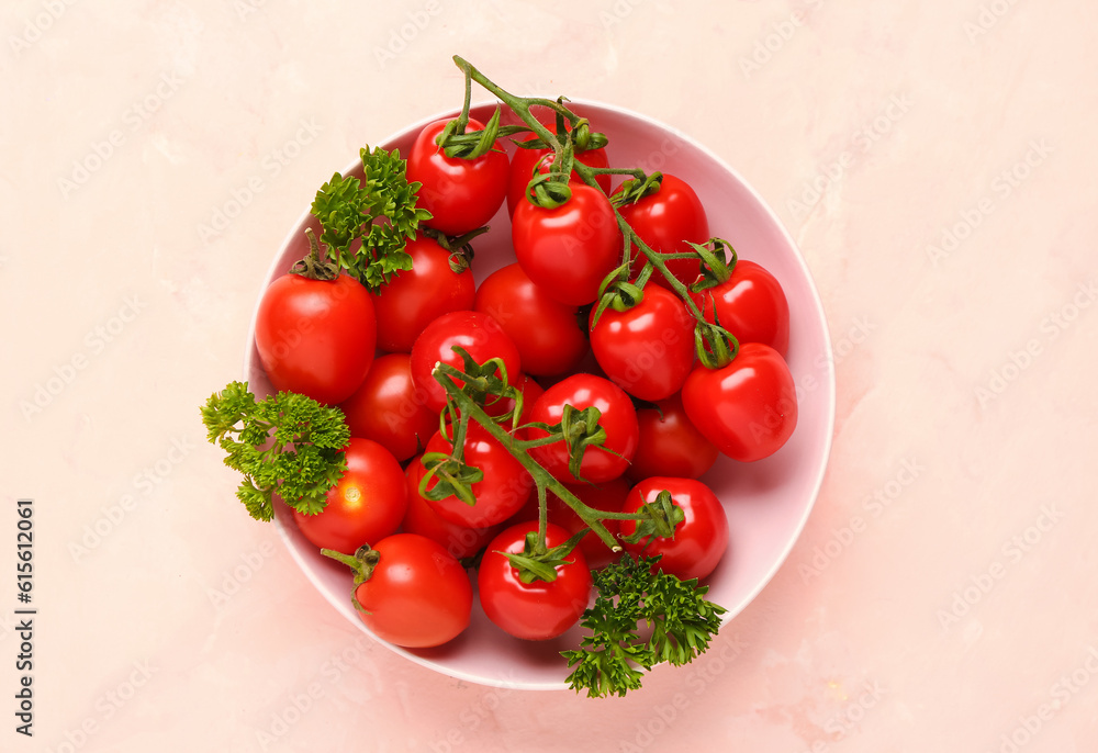 Bowl with fresh cherry tomatoes and parsley on pink background