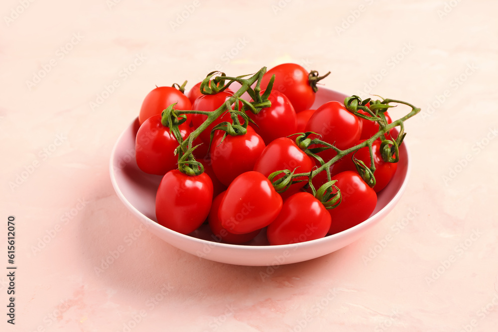 Bowl with fresh cherry tomatoes on pink background