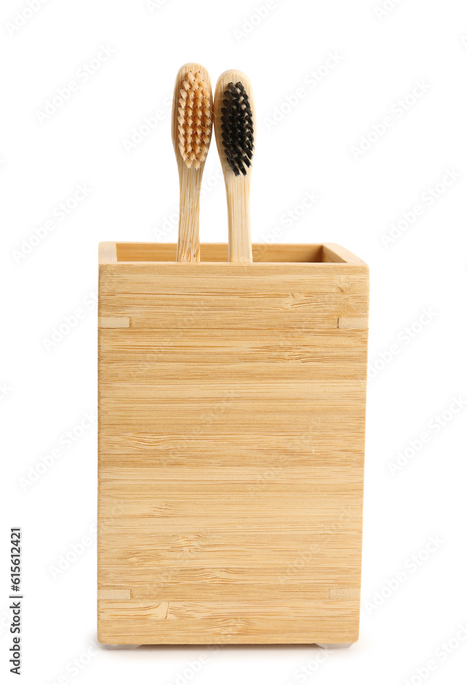 Bamboo tooth brushes in holder on white background