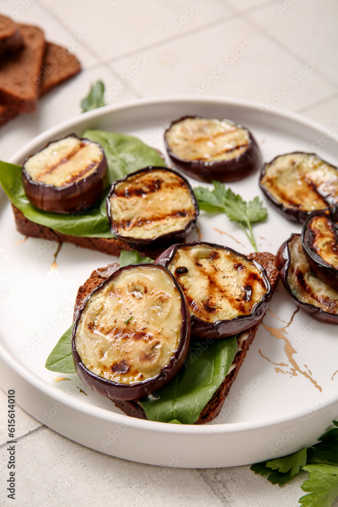 Toasts with delicious grilled eggplants on light background