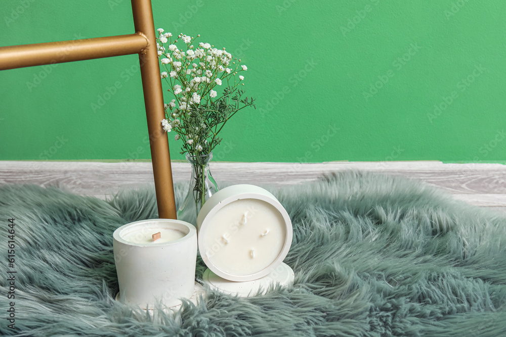 Ladder, gypsophila flowers and candles on soft rug in room