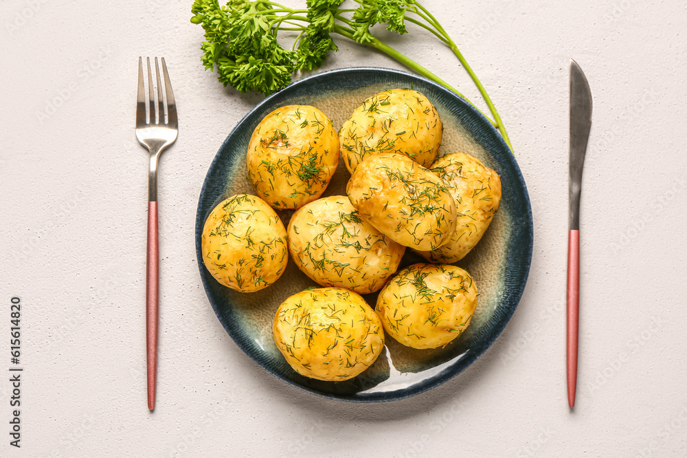 Plate of boiled baby potatoes with dill and parsley on white background