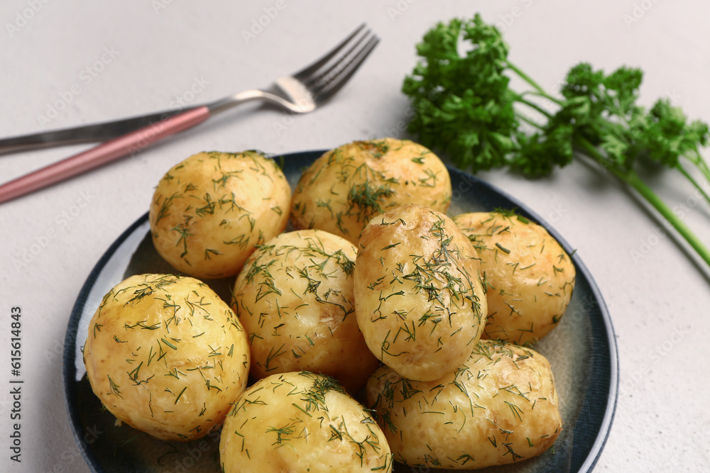 Plate of boiled baby potatoes with dill and parsley on white background