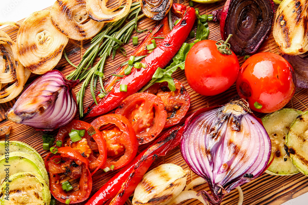 Wooden board with different tasty grilled vegetables, closeup