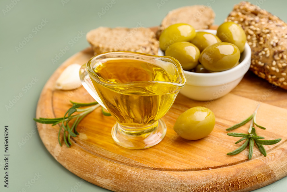 Gravy boat with fresh olive oil on green background