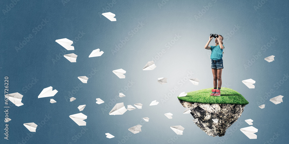 Concept of careless happy childhood with girl looking in binoculars