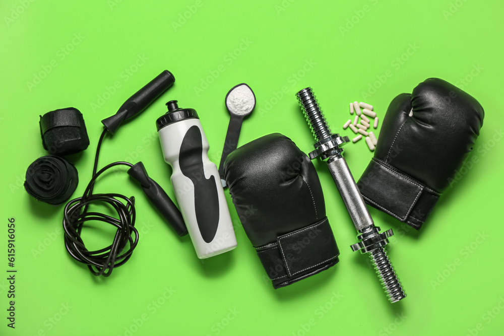 Composition with sports equipment, bottle of water and amino acid supplements on green background