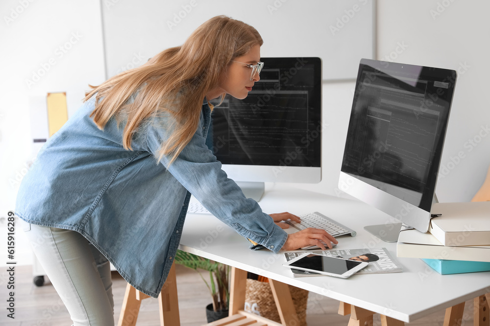 Female programmer working with computer at table in office