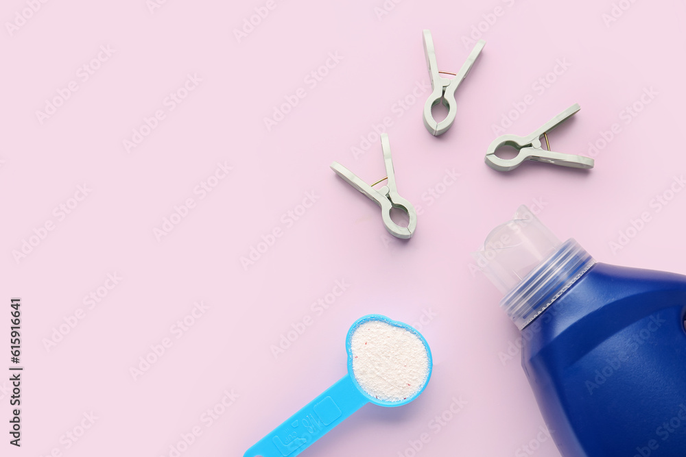 Laundry detergents and clothespins on pink background