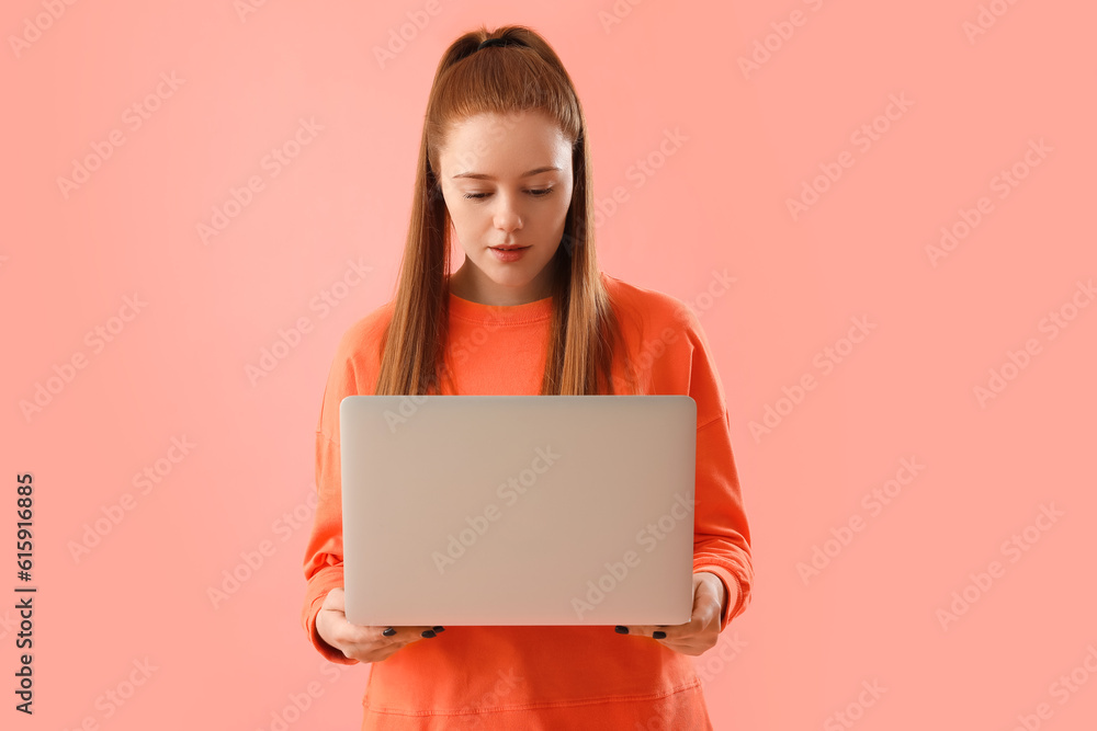 Female programmer with laptop on pink background