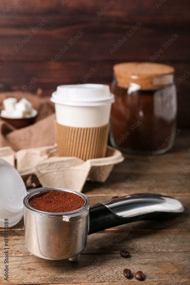 Scoop of coffee powder on wooden table, closeup