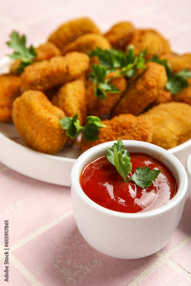 Bowl with tasty ketchup on pink tile background