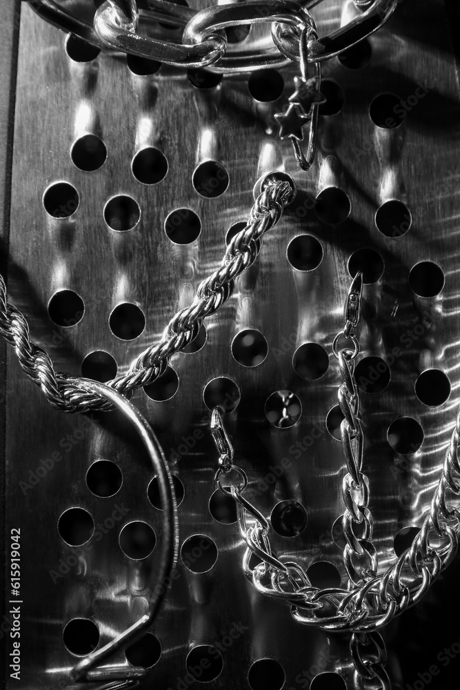 Grater with silver jewelry on black background, closeup