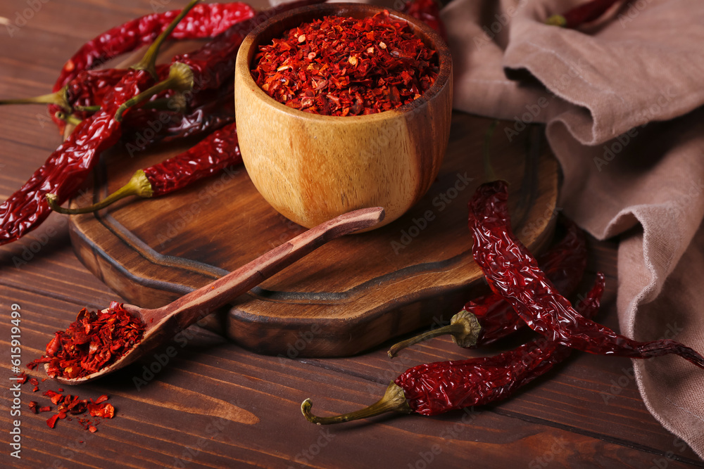 Composition with dry hot chili peppers and spice on brown wooden background