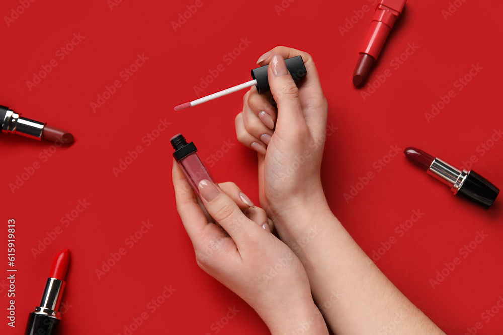 Woman with lipsticks on red background