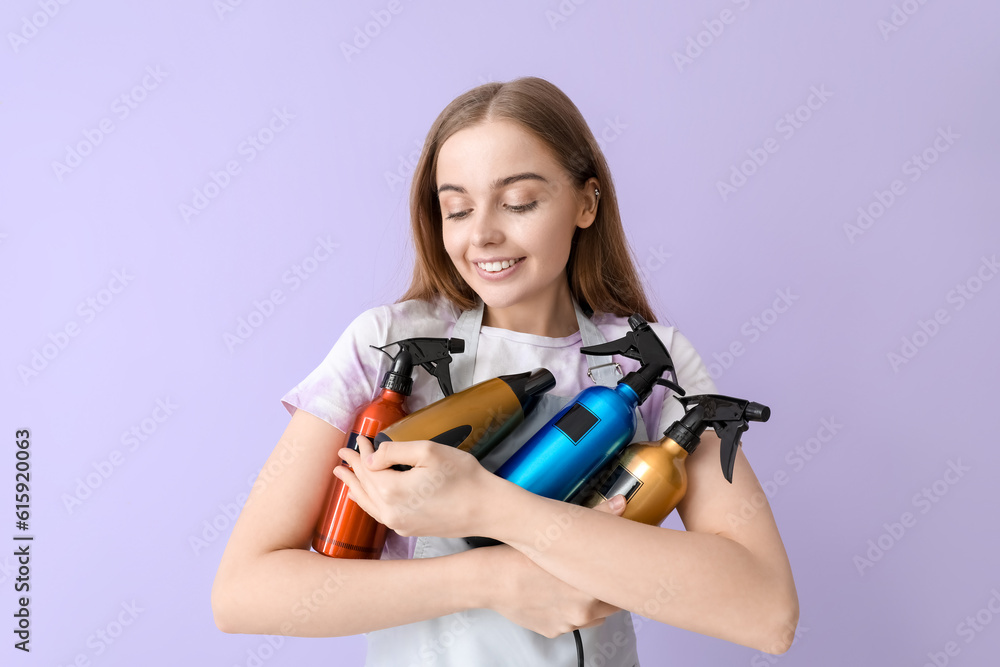 Female hairdresser with sprays and dryer on lilac background