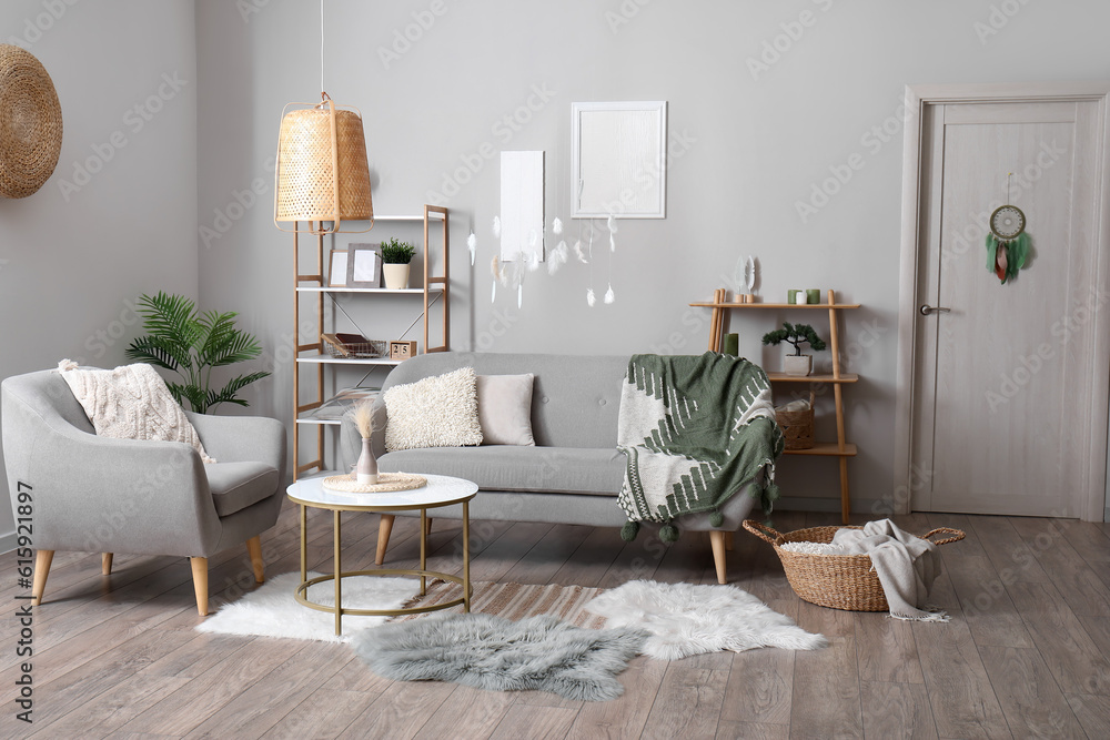 Interior of modern living room with sofa, armchair and dream catcher hanging on door and from ceilin