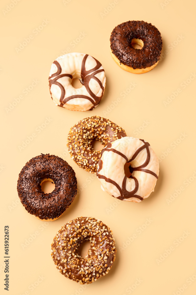 Sweet chocolate donuts on beige background