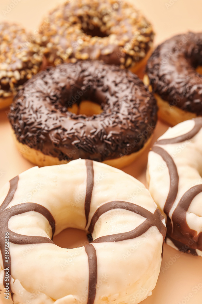 Sweet chocolate donuts on beige background