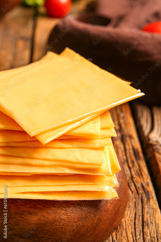 Slices of tasty processed cheese on wooden background