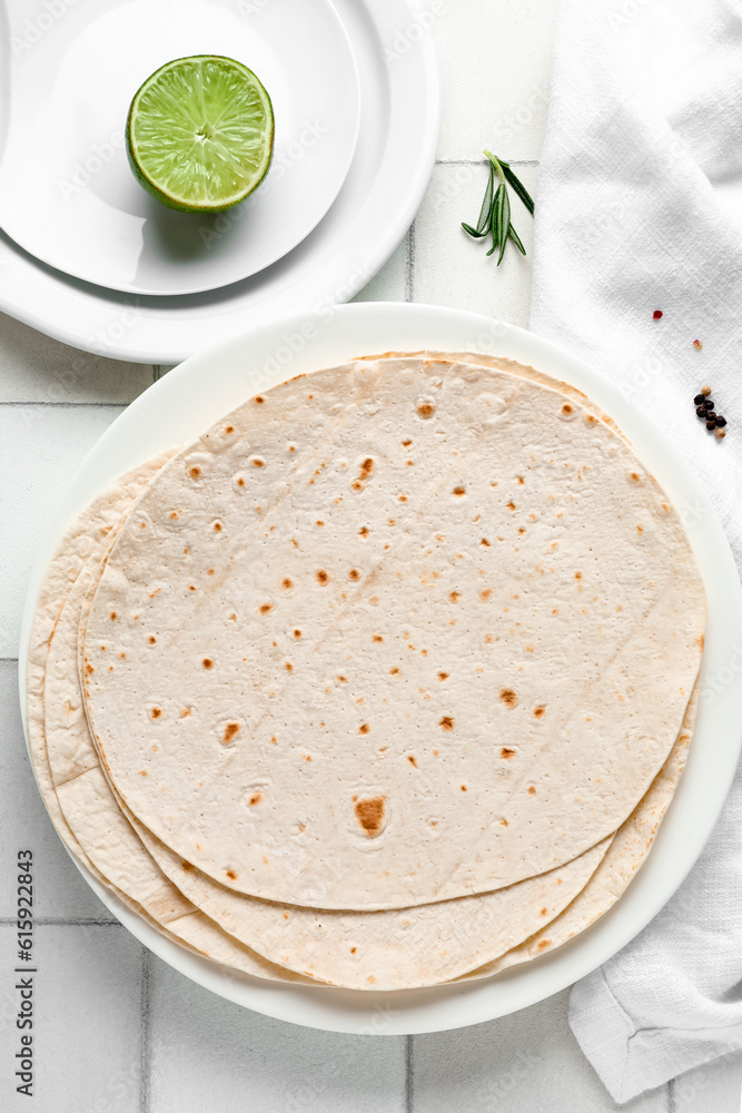 Plate with fresh lavash on white tile background