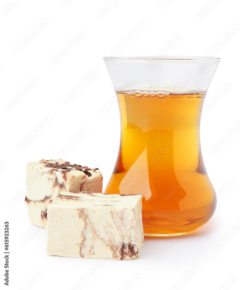 Glass of Turkish tea and pieces of tasty marble halva on white background