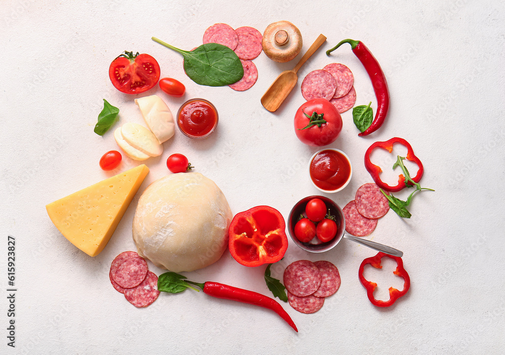 Frame made of different ingredients for preparing pizza on light background