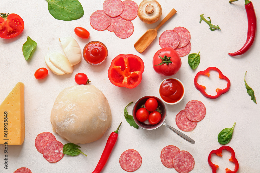 Different ingredients for preparing pizza on light background