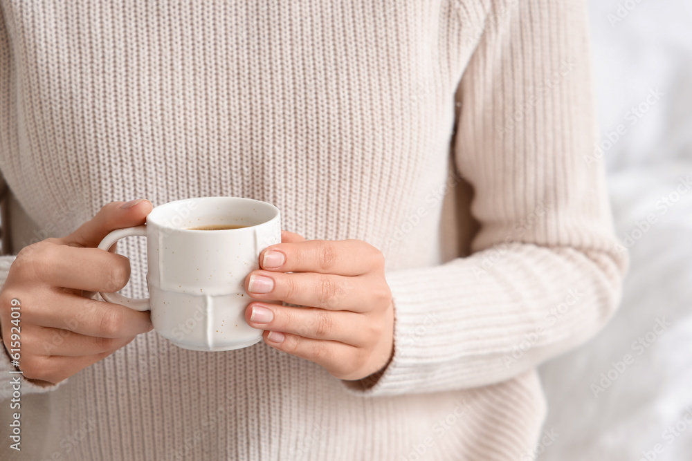 Woman holding cup of delicious coffee