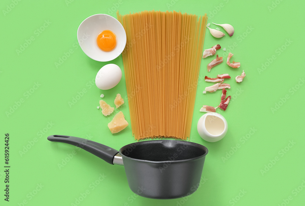 Composition with pot and ingredients for tasty pasta carbonara on green background