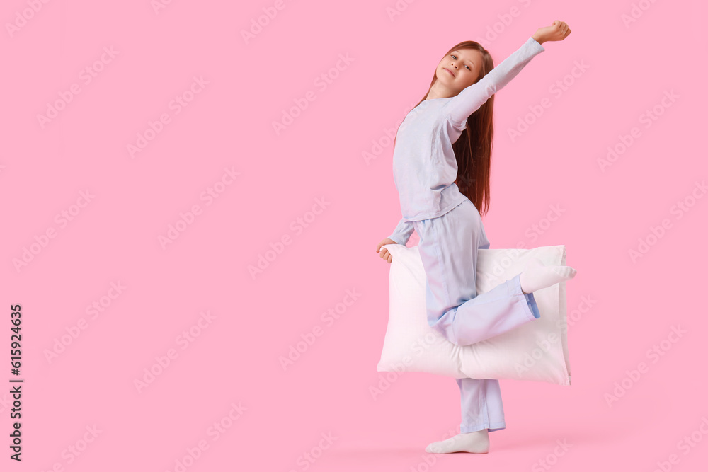 Little girl with pillow on pink background