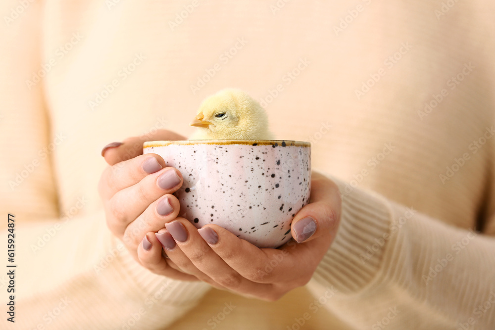 Beautiful young woman holding cup with cute yellow chick