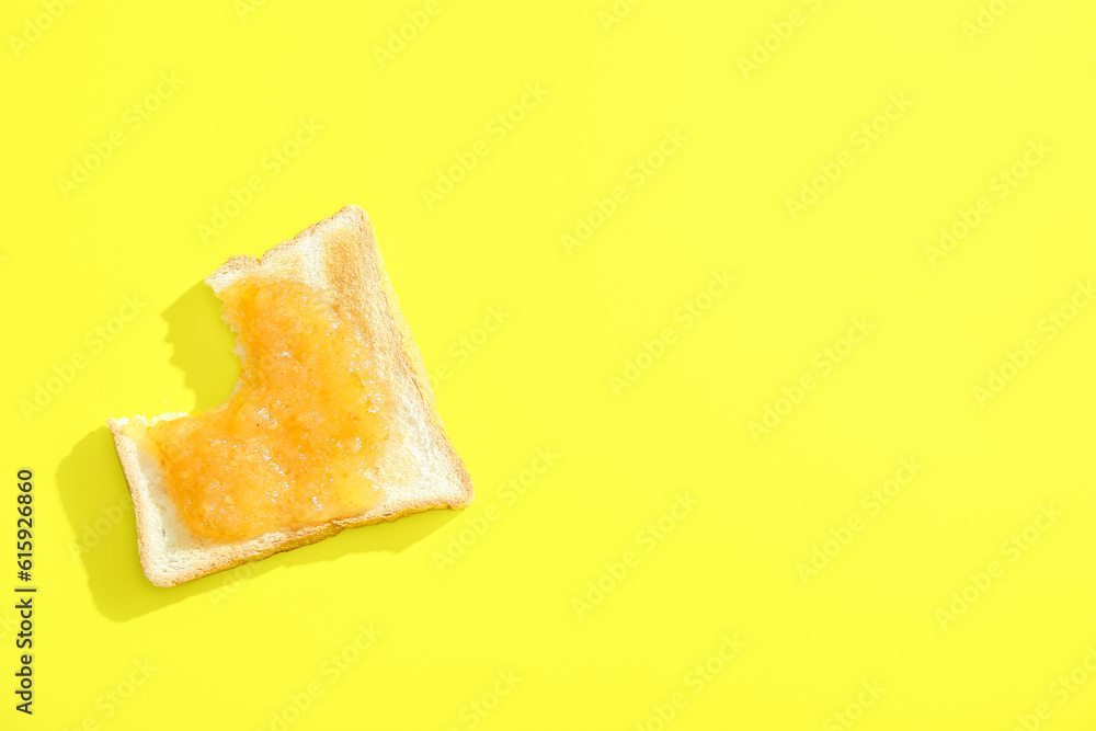 Bitten toast with sweet jam on yellow background