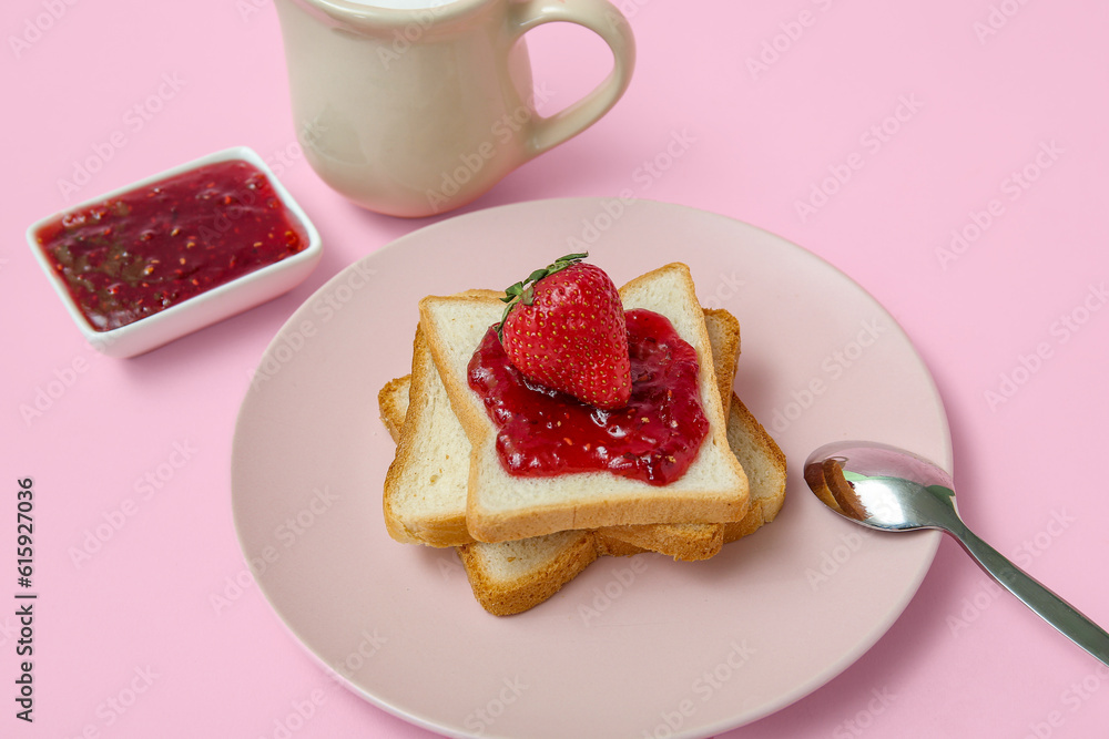 Plate of tasty toasts with strawberry jam and milk in pitcher on pink background