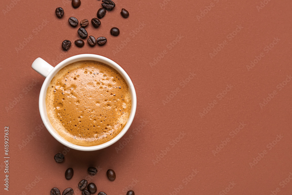 Cup of hot espresso and coffee beans on brown background