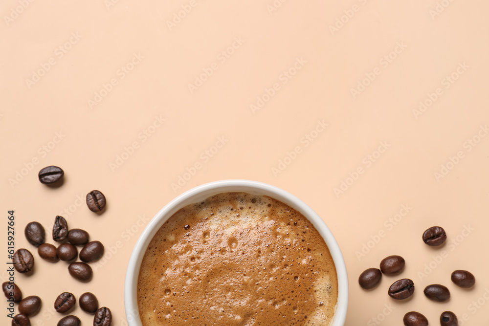 Cup of hot espresso and coffee beans on beige background