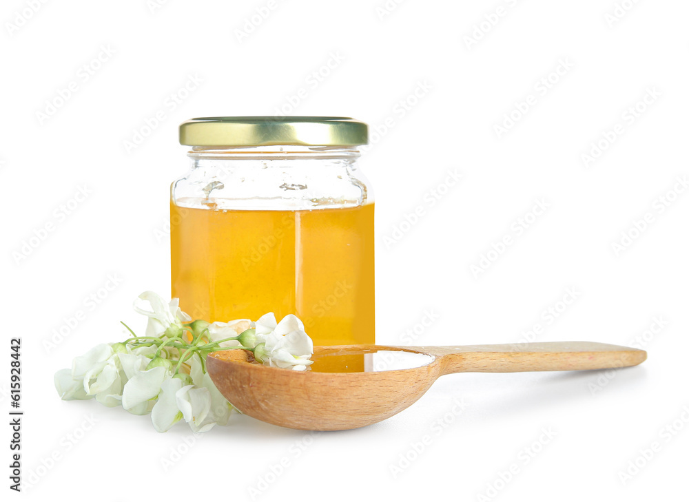 Jar and spoon of honey with flowers of acacia on white background