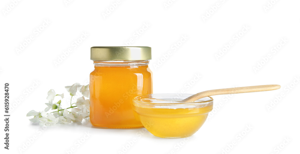 Bowl and jar of honey with flowers of acacia on white background