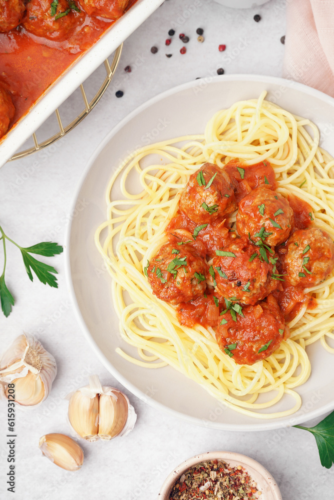 Plate of boiled pasta with tomato sauce and meat balls on white table