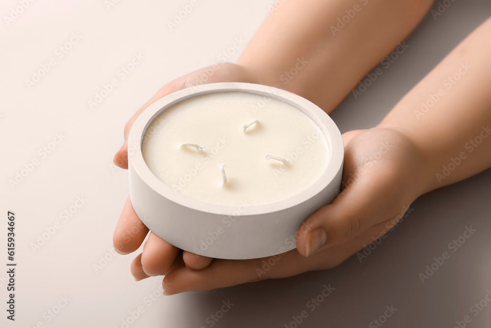 Female hands with candle on light background, closeup