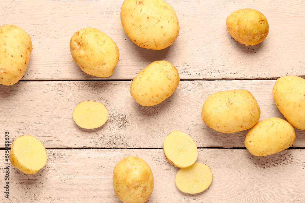 Raw baby potatoes on white wooden background