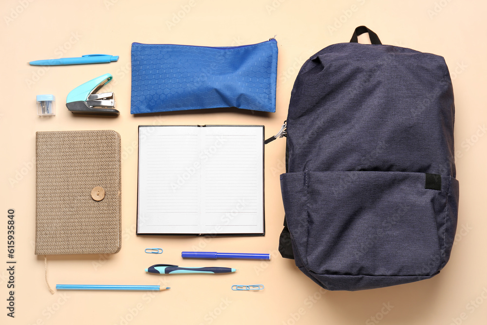 Notebooks with backpack, pencil case and different stationery on pale orange background