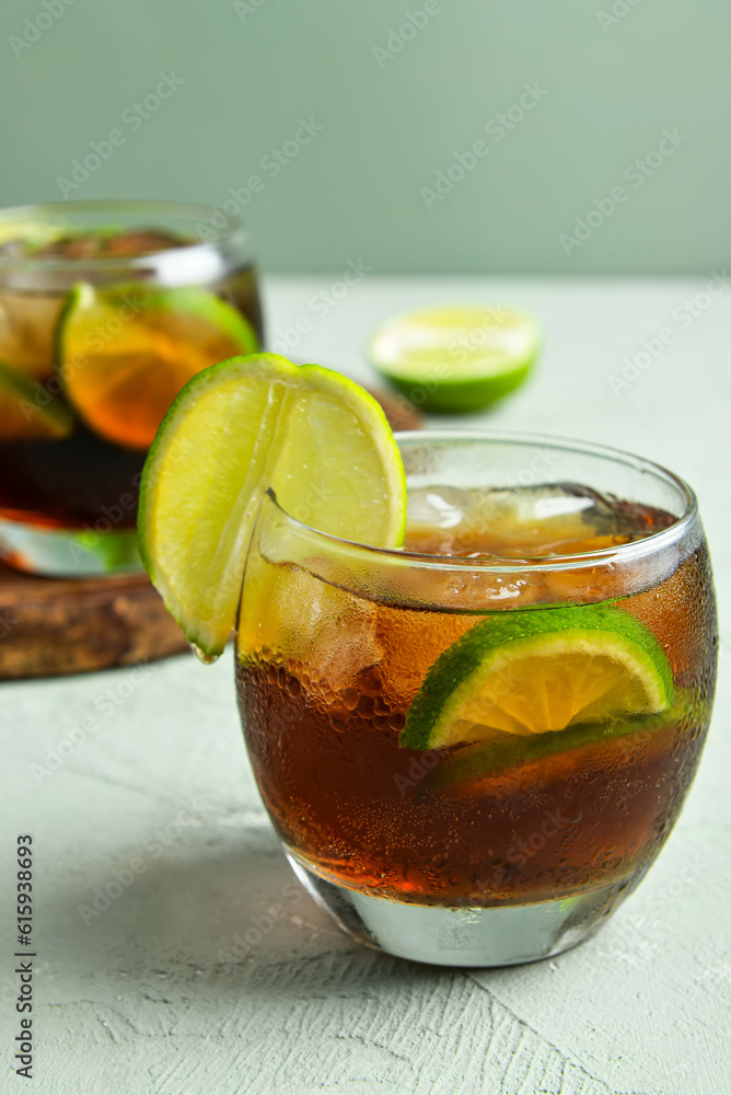 Glasses of cold Cuba Libre cocktail on grey background