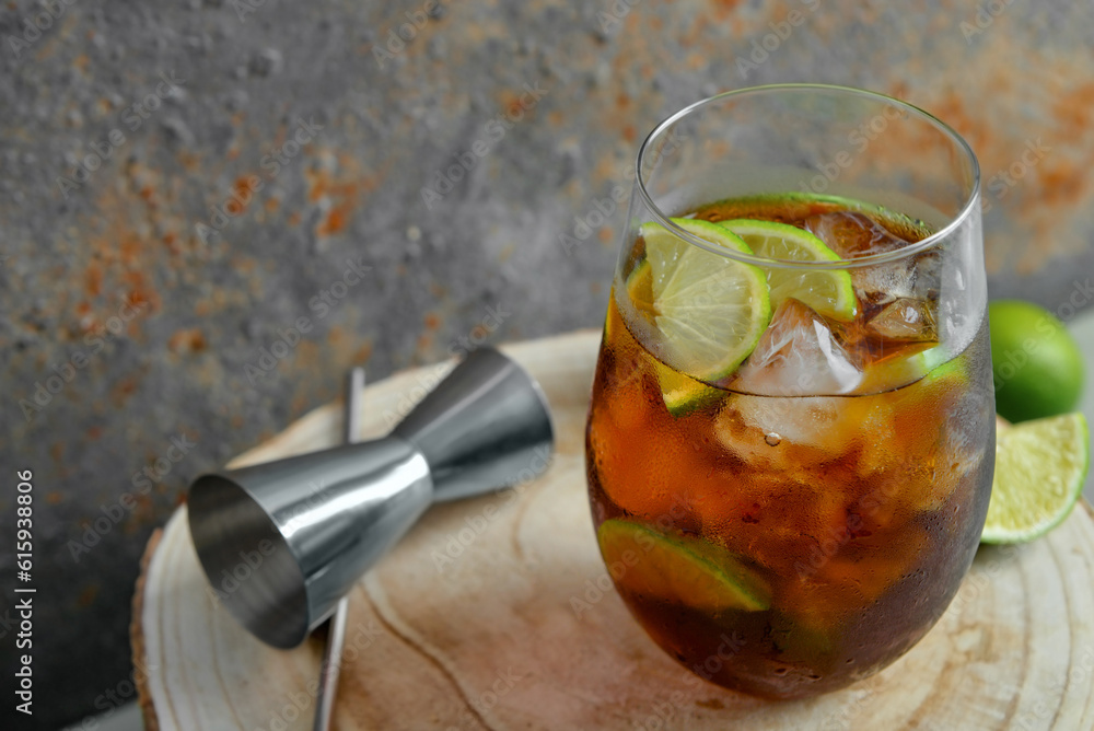 Glass of cold Cuba Libre cocktail on wooden table