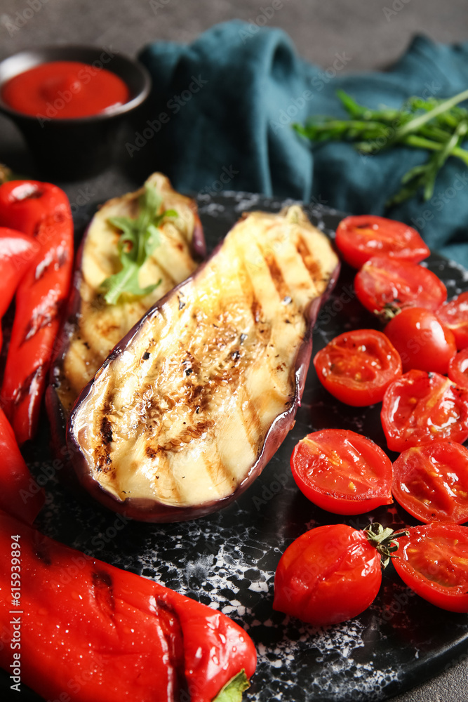 Board with tasty grilled vegetables on black background