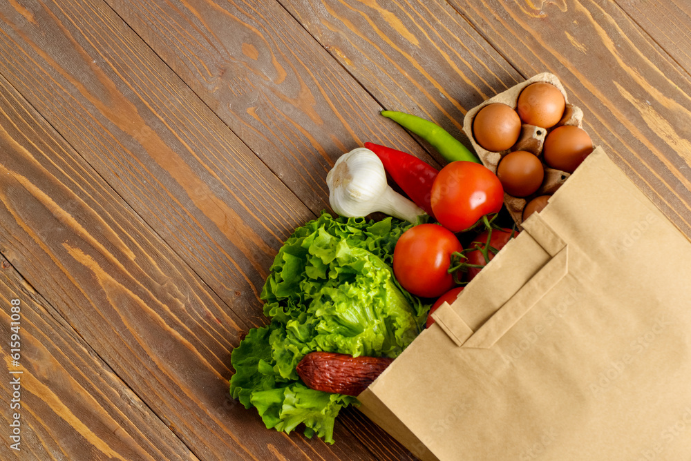 Paper bag with different products on wooden background