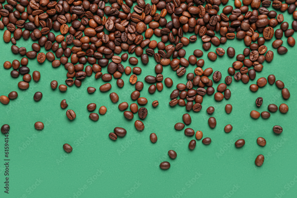 Scattered coffee beans on green background